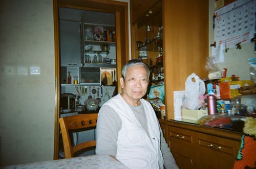 Free Senior man sitting in a warm, homey kitchen. Casual and relaxed atmosphere. Stock Photo