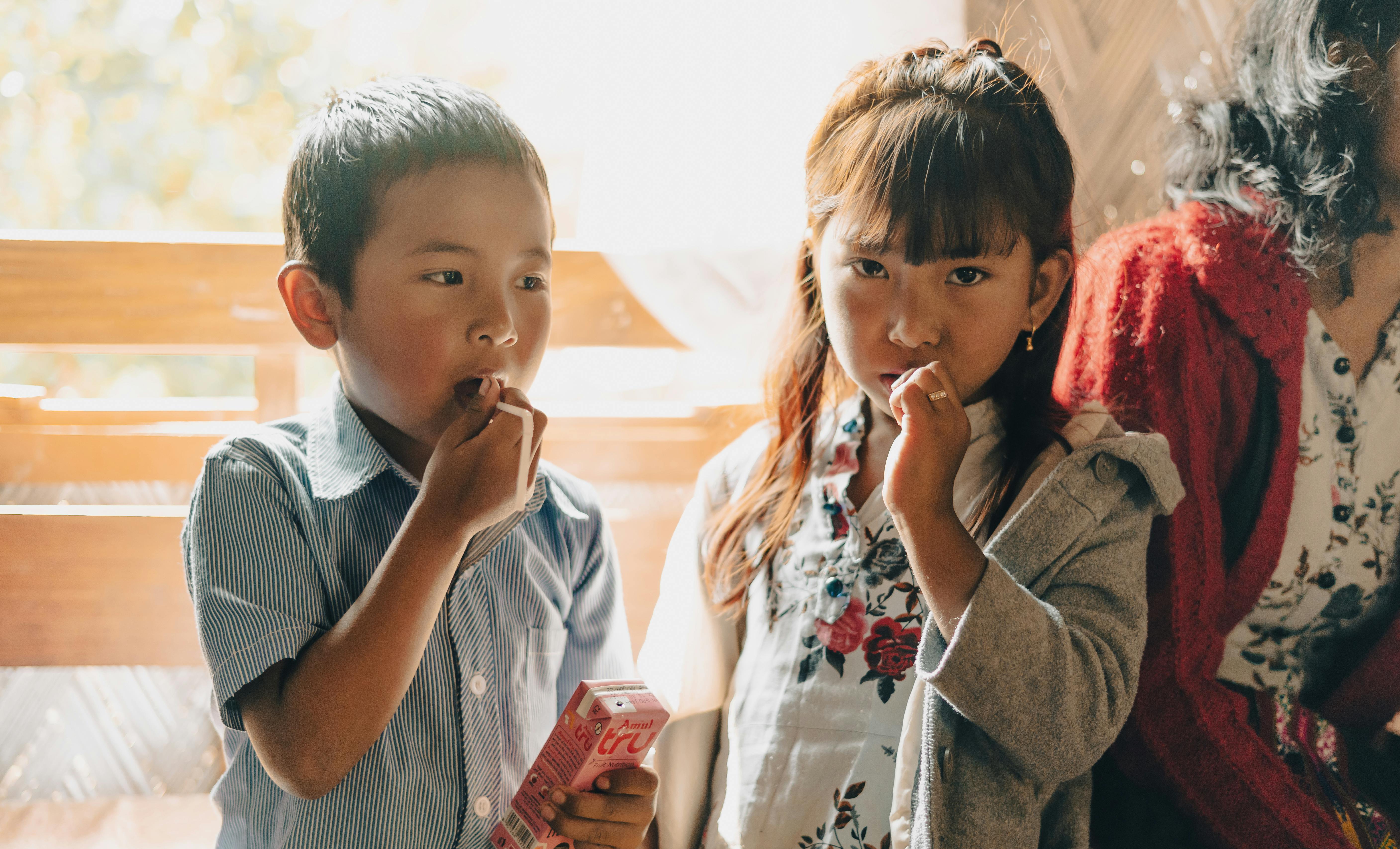 two children and one adult eating candy