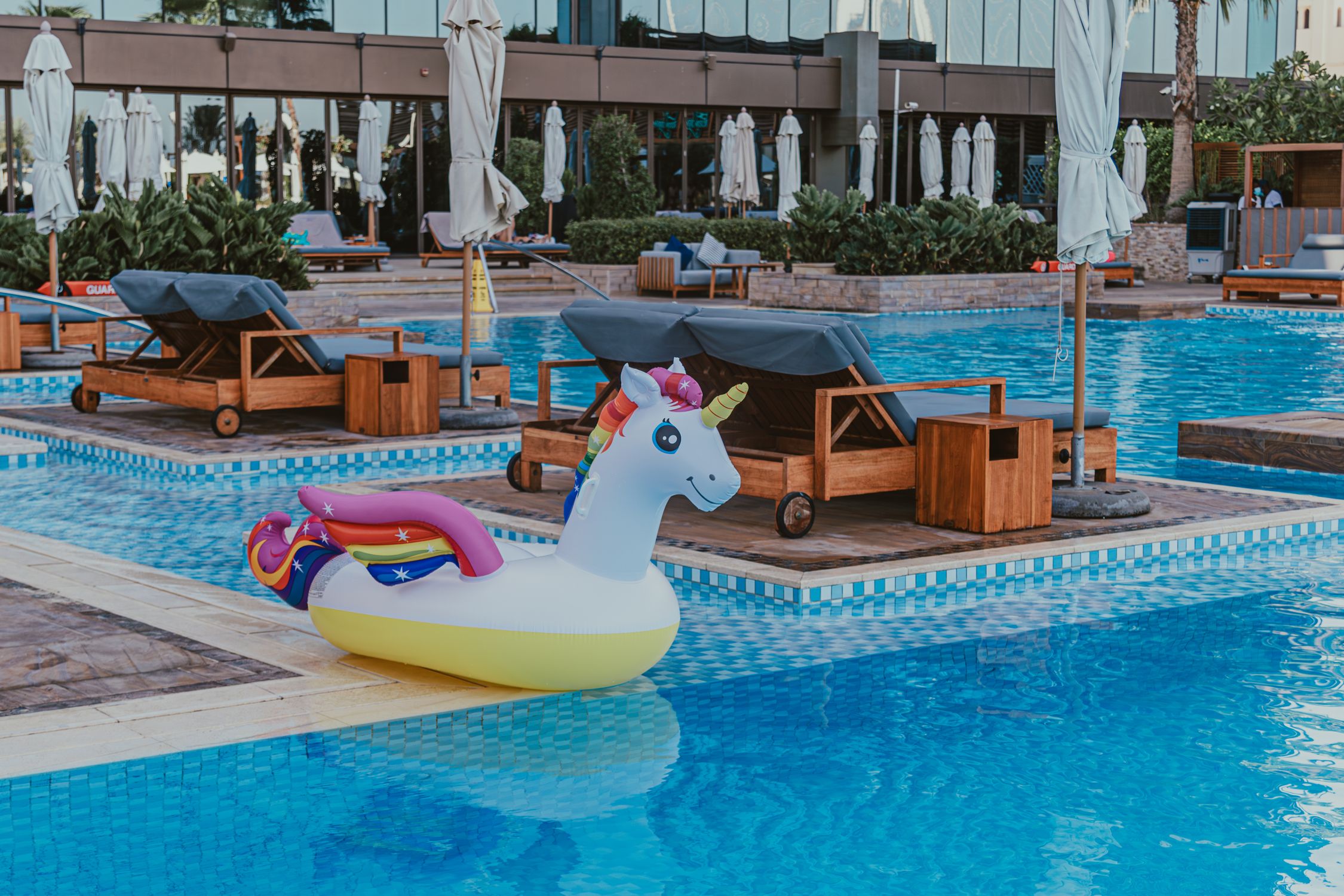 Inflatable Pool Colorfull Colorful inflatable unicorn float in a modern swimming pool at a resort ...