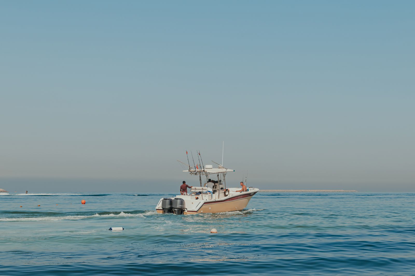Sport-fishing boat with anglers on calm Gulf waters off Dubai