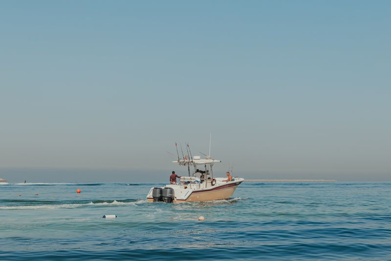 Sport-fishing boat with anglers on calm Gulf waters off Dubai