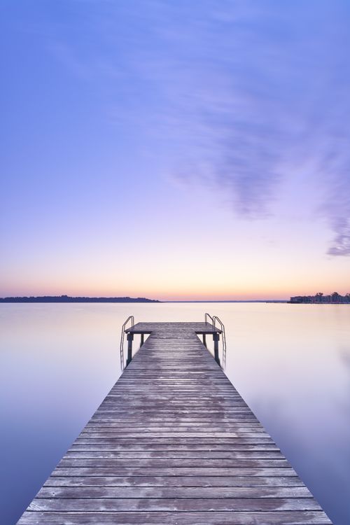 Free Serene view of a wooden jetty over calm waters at Chiemsee, perfect for a tranquil escape. Stock Photo