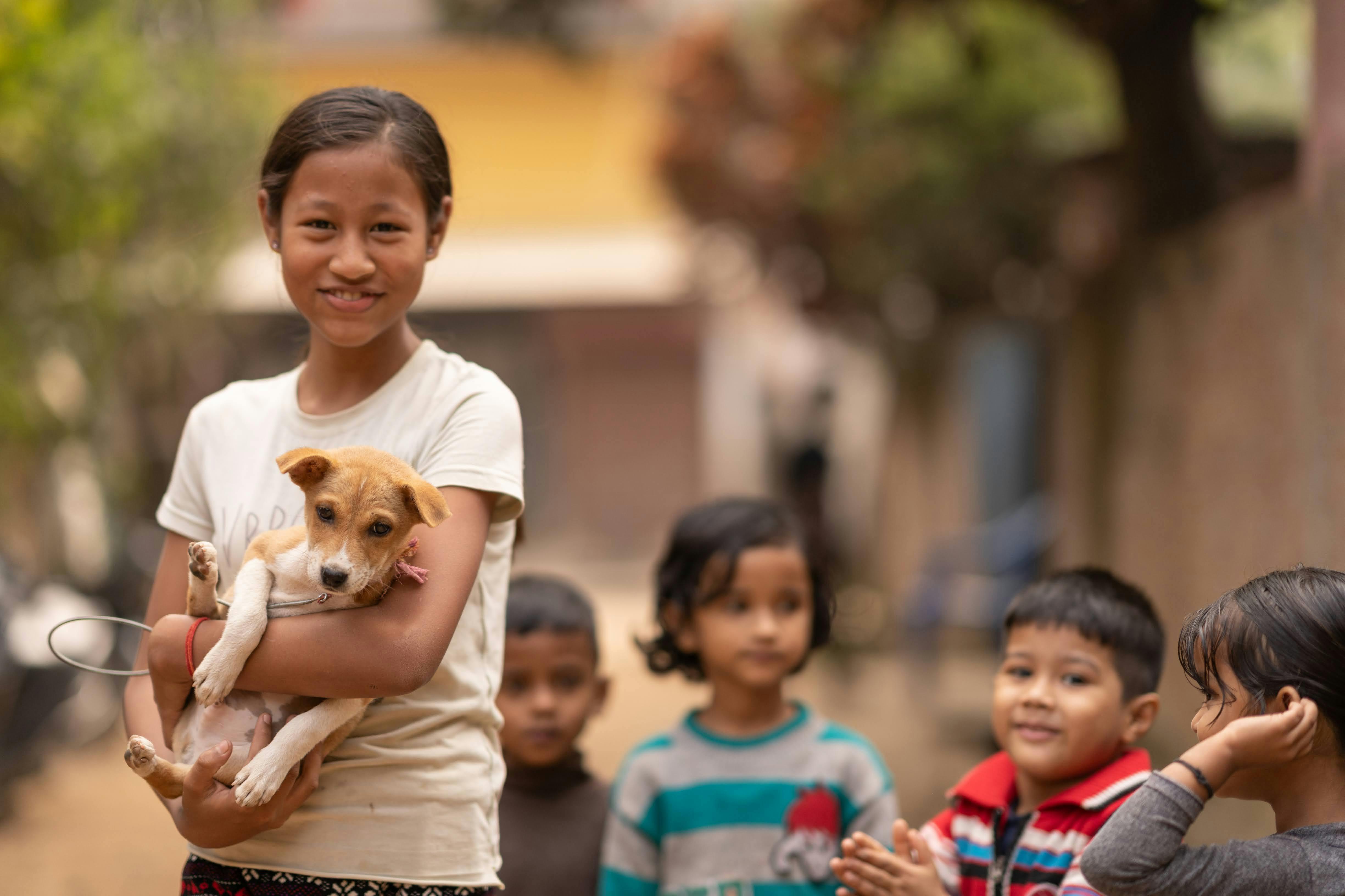 A young girl holding a small dog in her arms