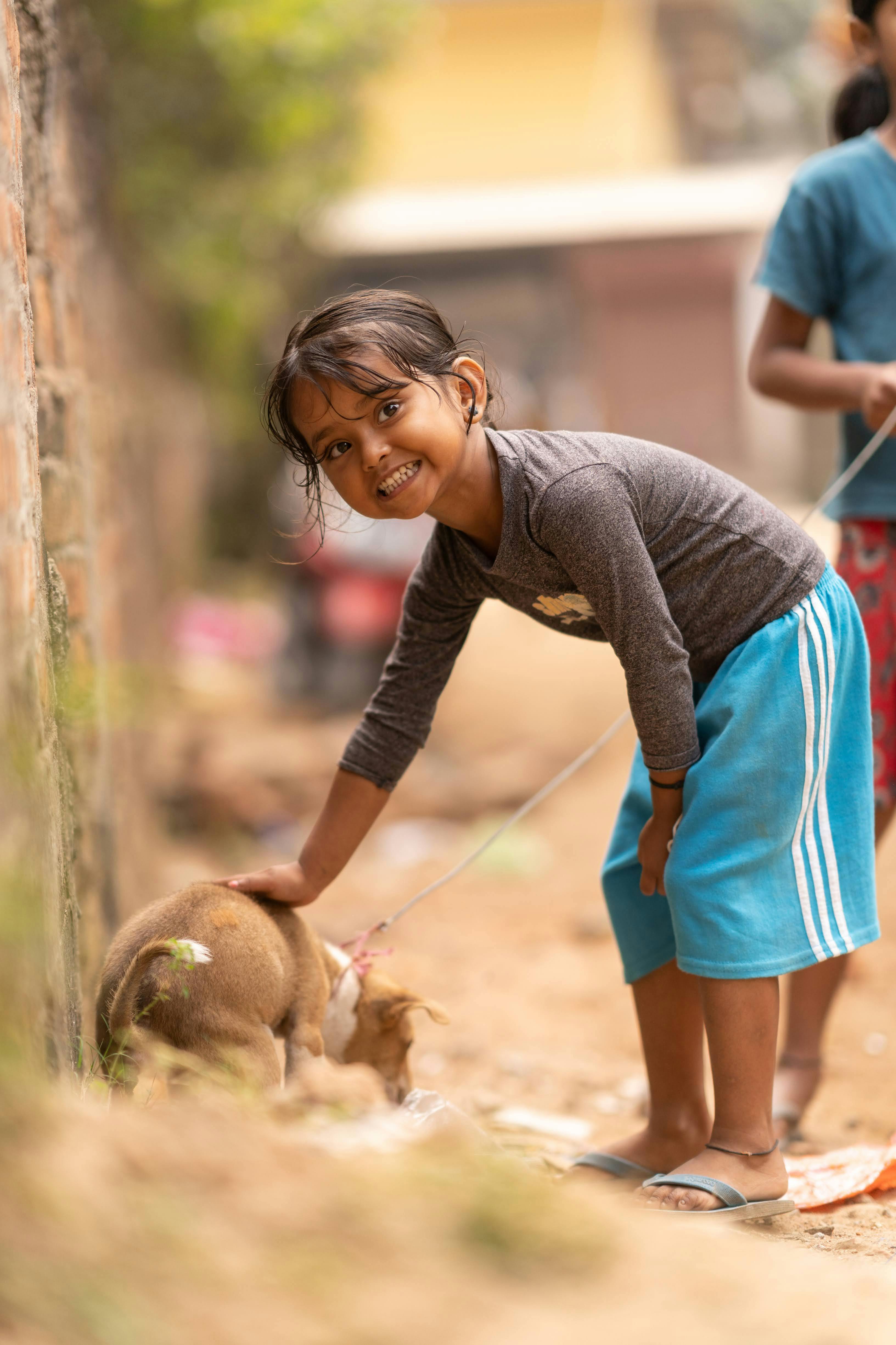 a young girl is petting a dog on the ground