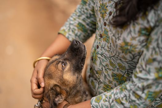 A woman affectionately holds a dog outdoors, showcasing a loving bond.