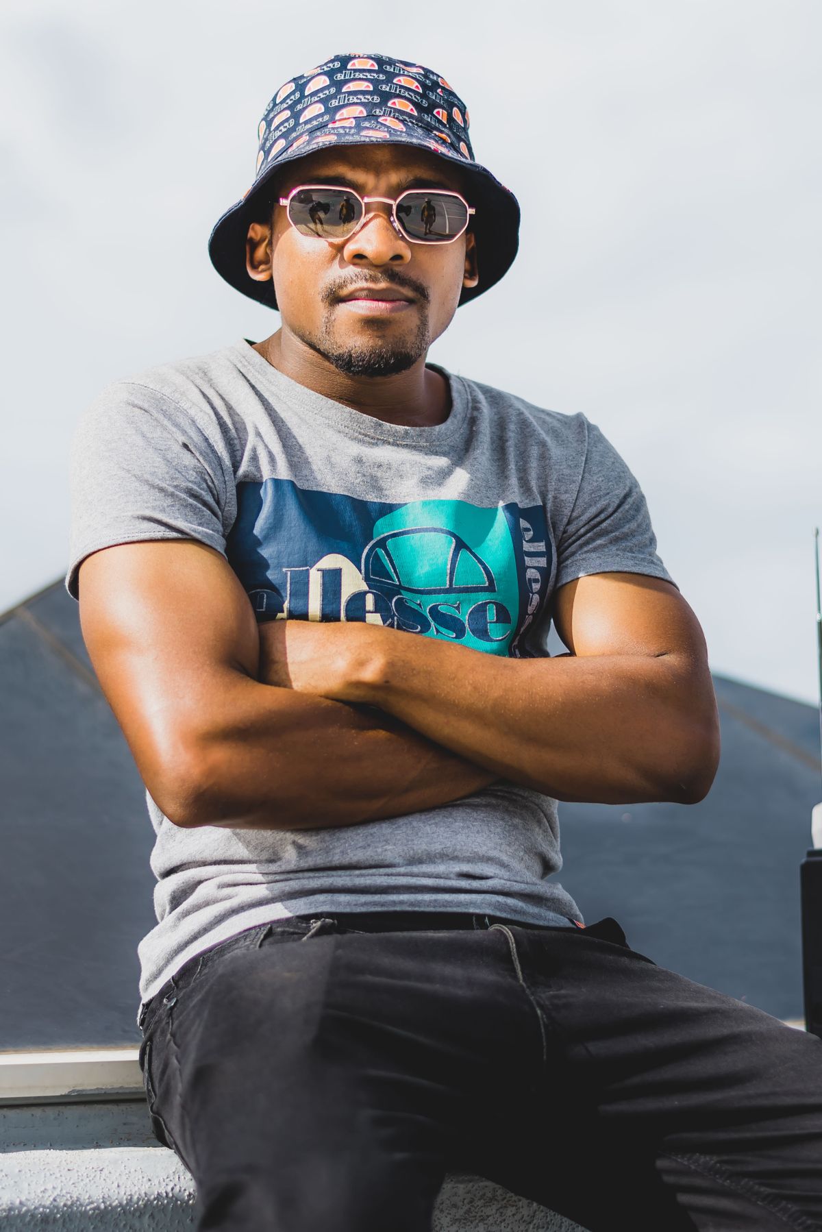 Man wearing a bucket hat and sunglasses outdoors