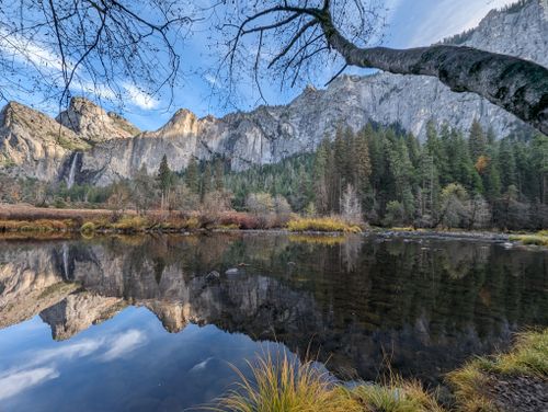 Free A serene river reflecting the majestic mountains of Yosemite National Park in fall. Stock Photo