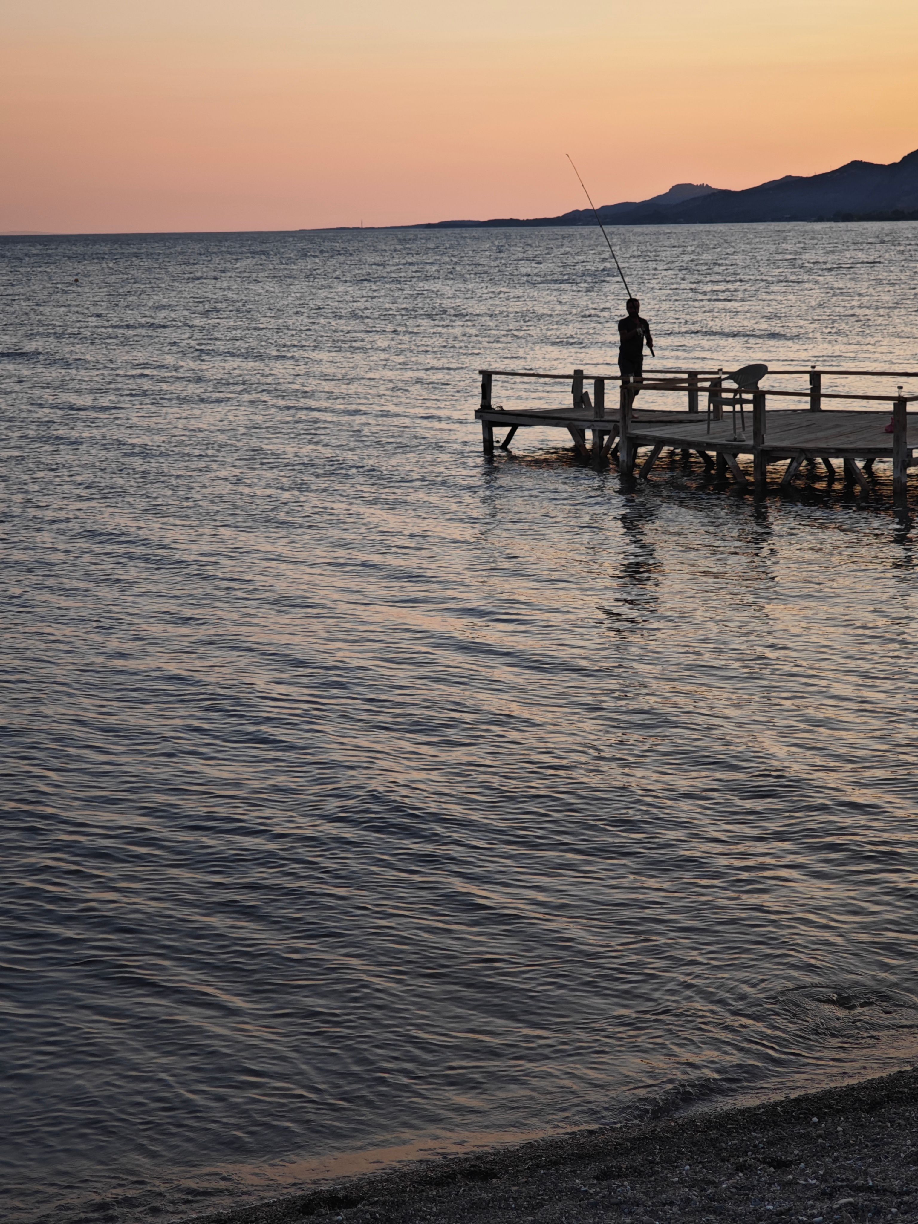 Silhouette of Fisherman on Sea Shore at Sunset · Free Stock Photo