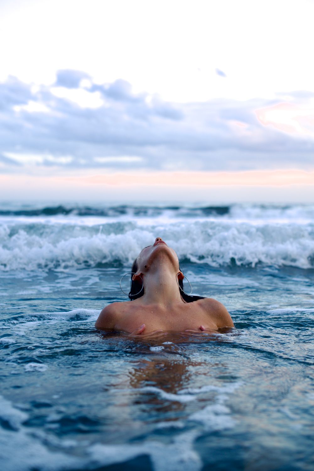 Woman in cold open water at dusk