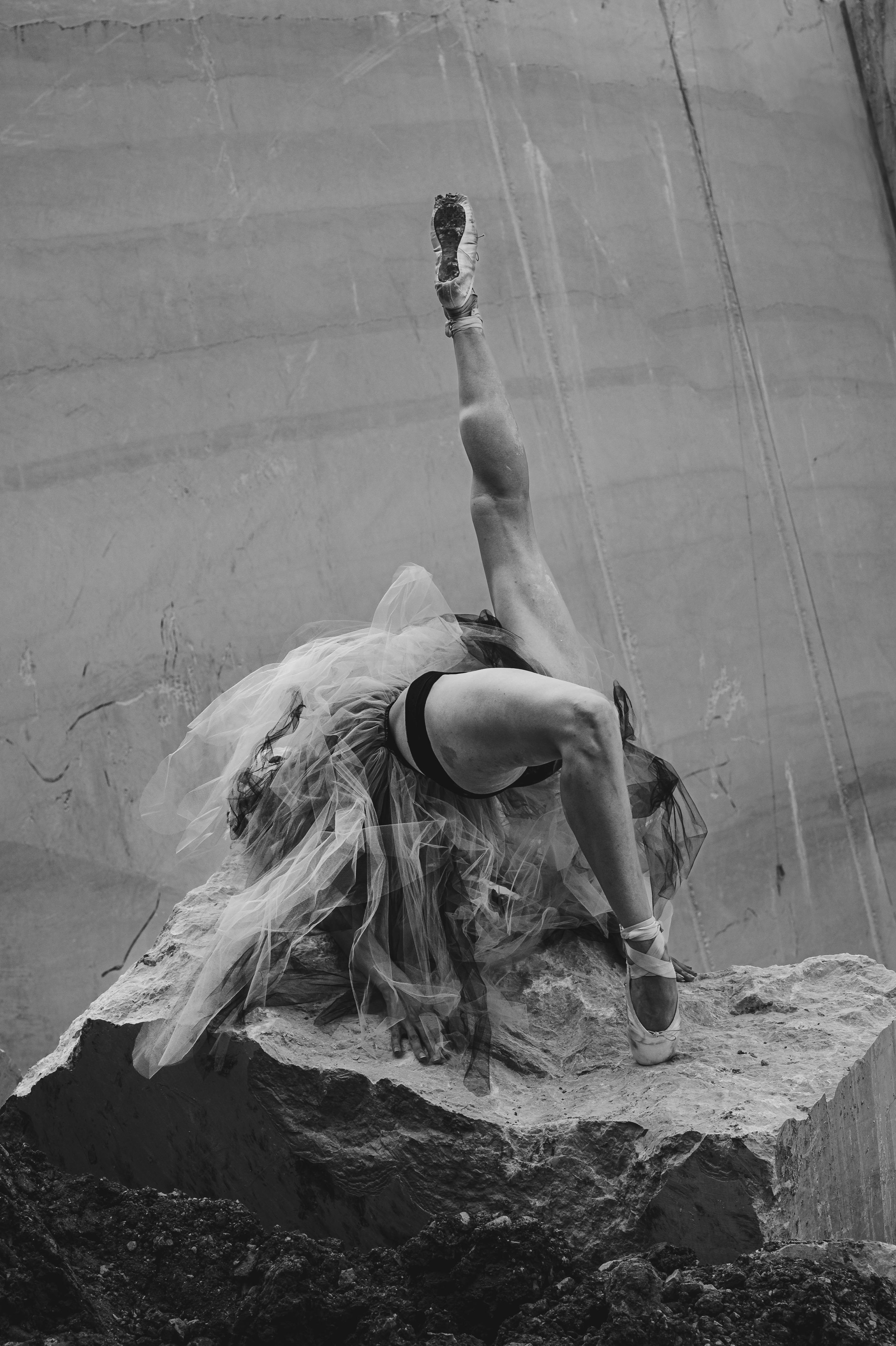Elegant ballerina performing a unique pose on a rock in Botticino, Italy.