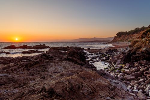 Free Breathtaking view of Cambria's rocky coast at sunset, showcasing natural beauty. Stock Photo
