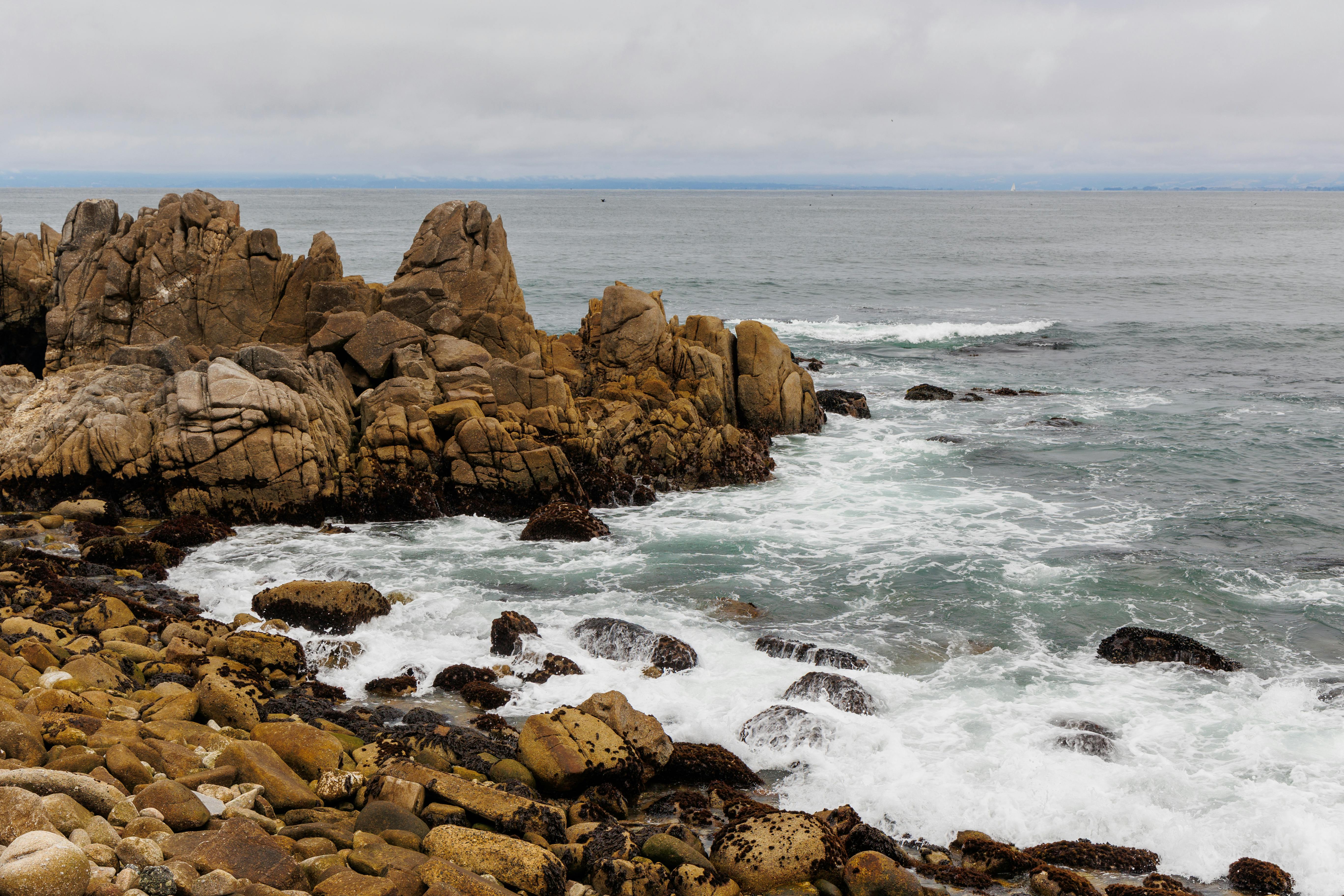 a rocky shoreline with waves crashing on the rocks
