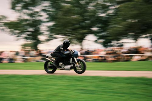 Free Dynamic motorcycle racing with helmeted rider at Malle Mile event in Grimsthorpe, UK. Stock Photo