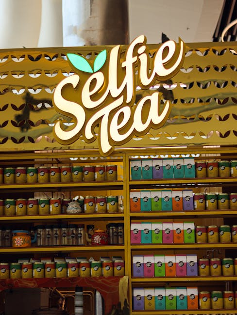 A vibrant display of packaged Greek Mountain Tea in a modern health food store, with shoppers browsing the herbal tea aisle
