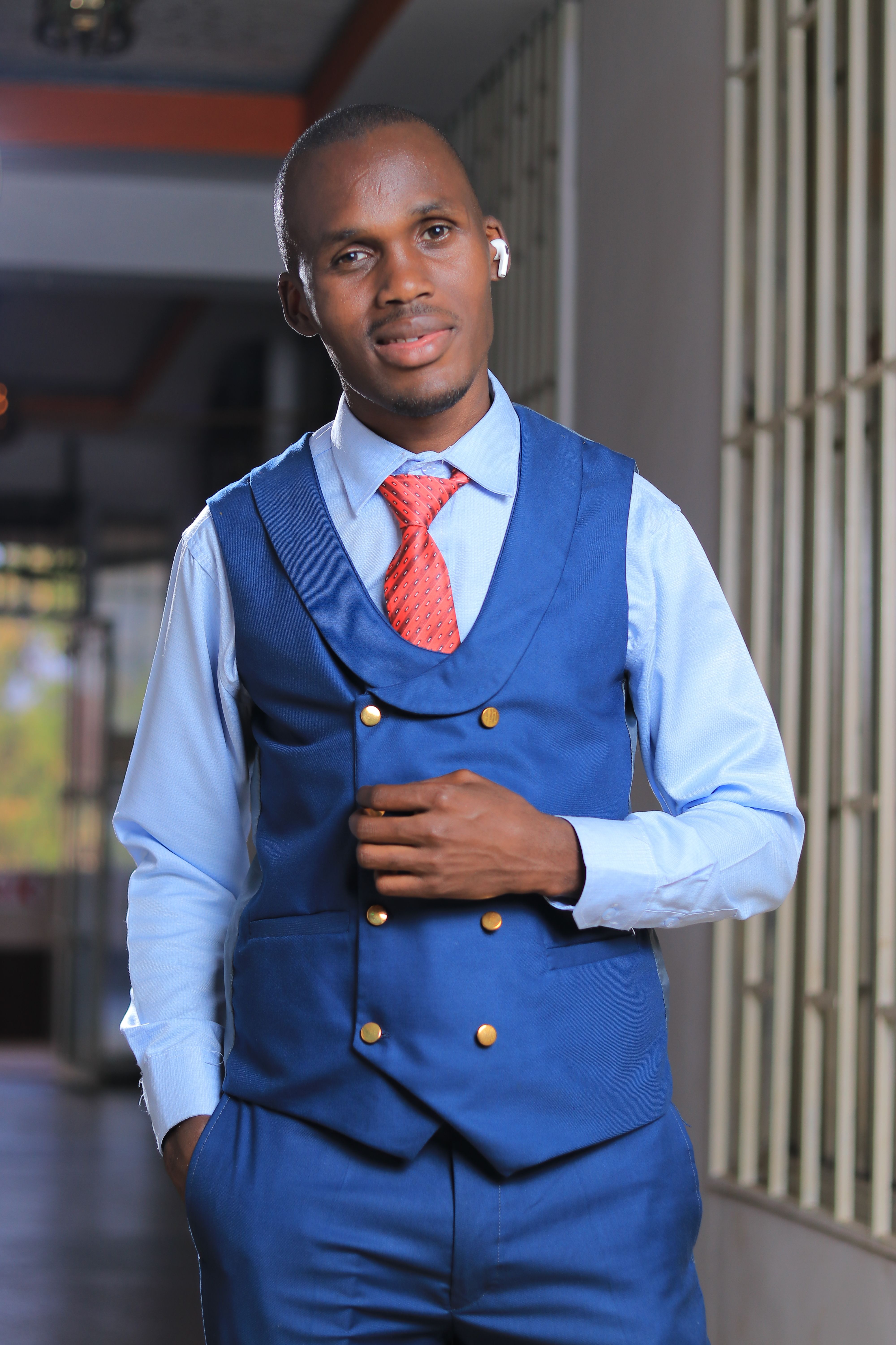 Portrait of a fashionable man in smart attire standing confidently indoors.