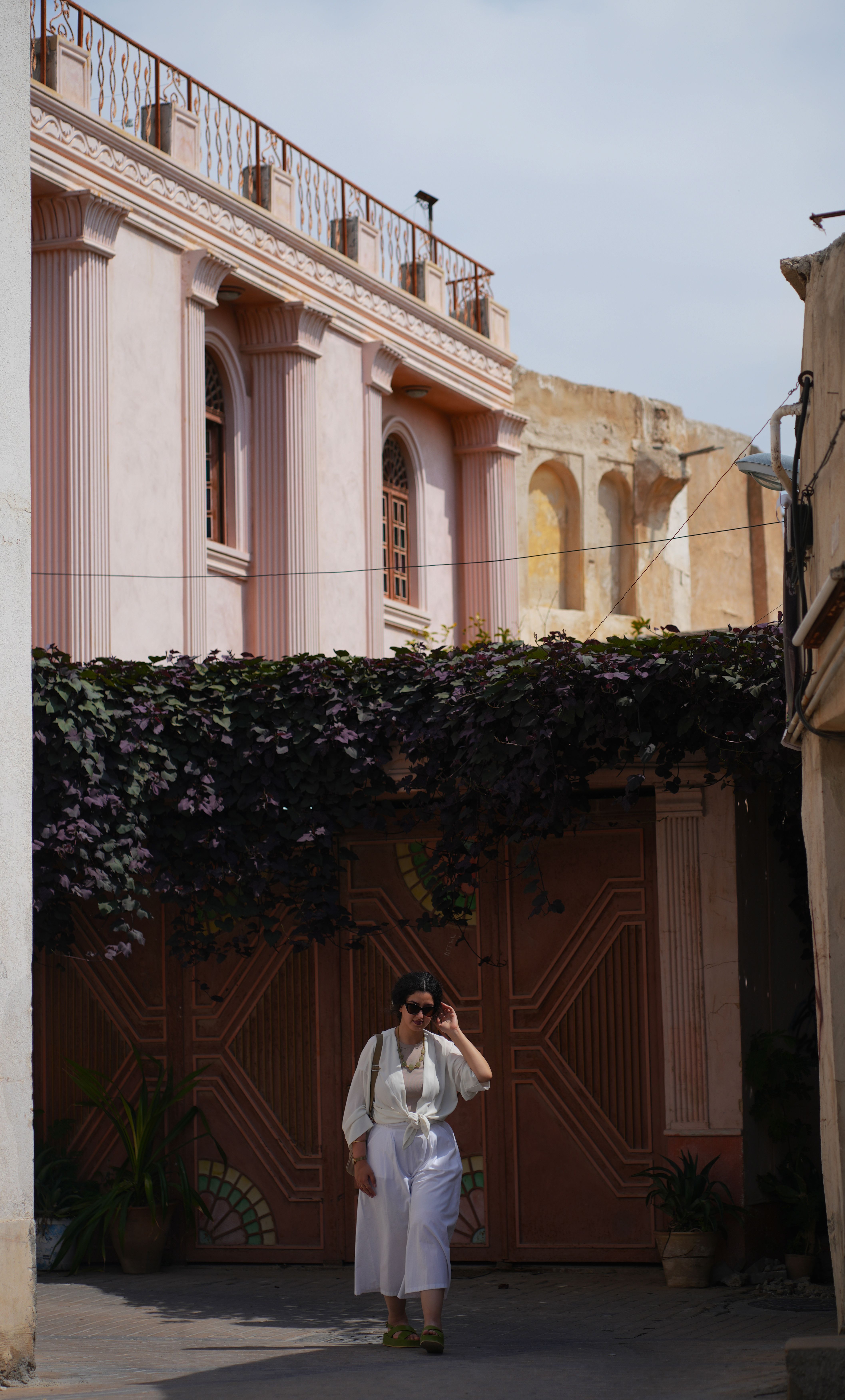 A woman in a white dress walking down a narrow alley · Free Stock Photo