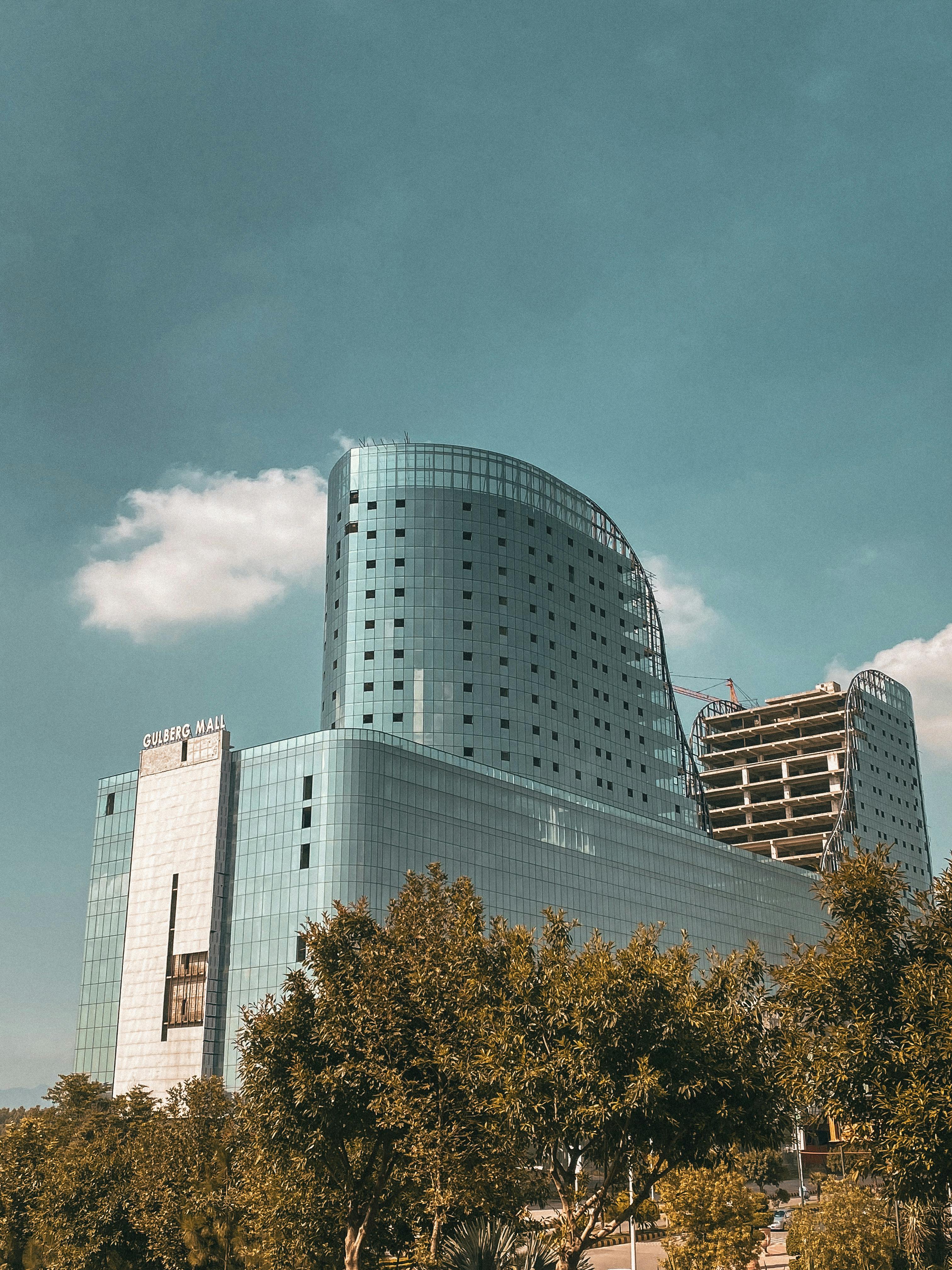 A contemporary skyscraper reflecting urban architecture under a clear sky.