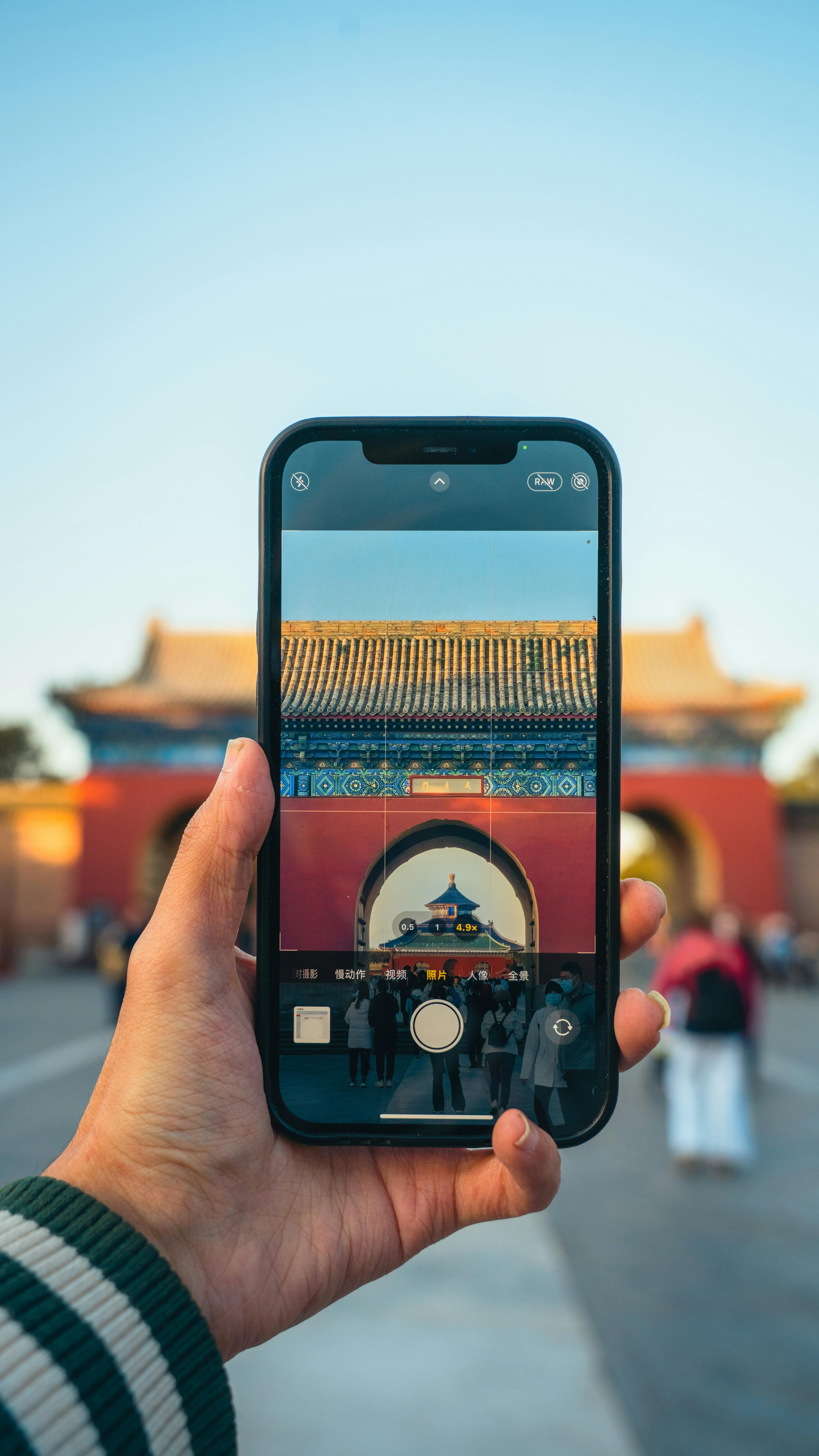 man hand holding smartphone and taking pictures of temple of heaven in beijing