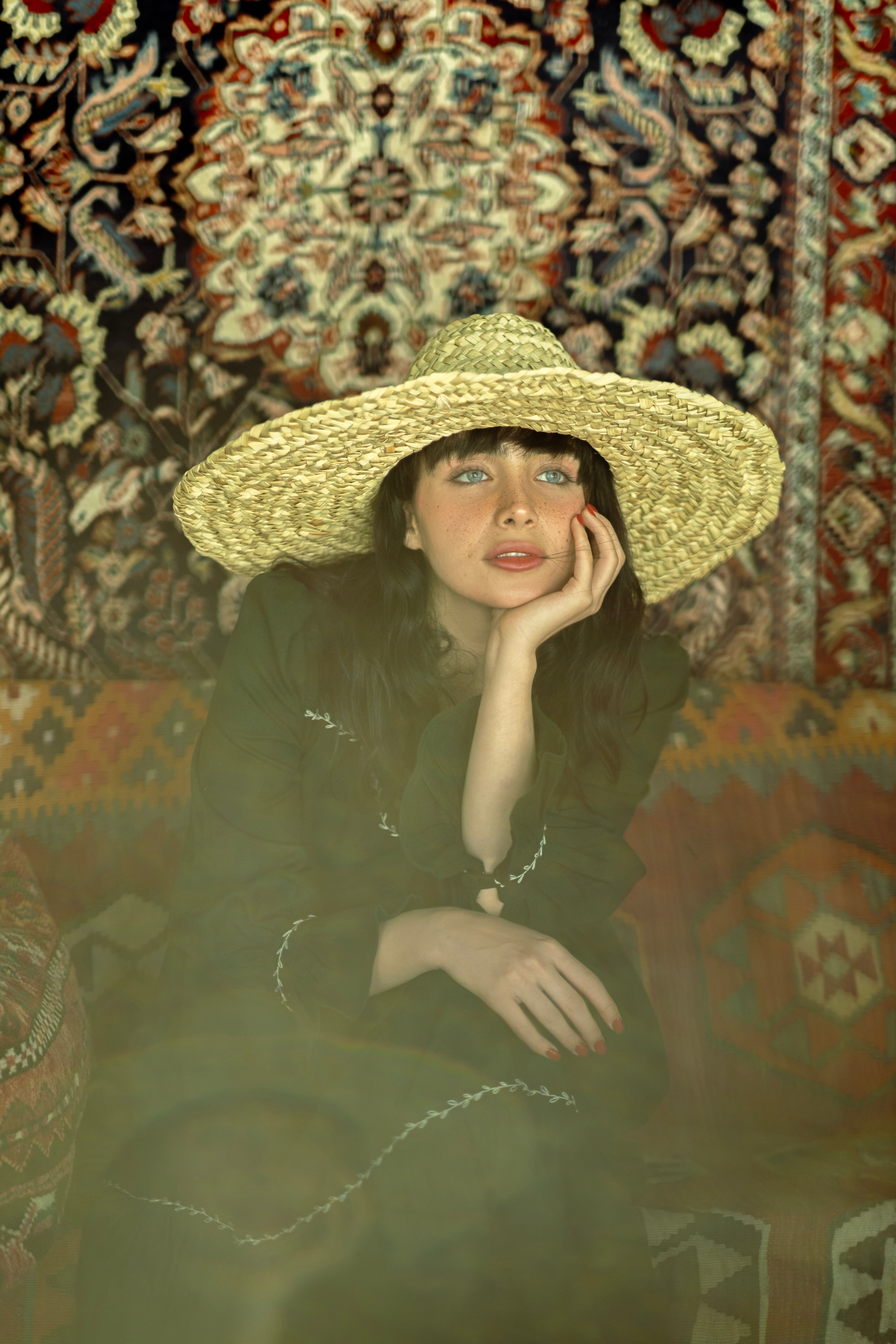 Woman in Hat Sitting with Hand on Cheek · Free Stock Photo
