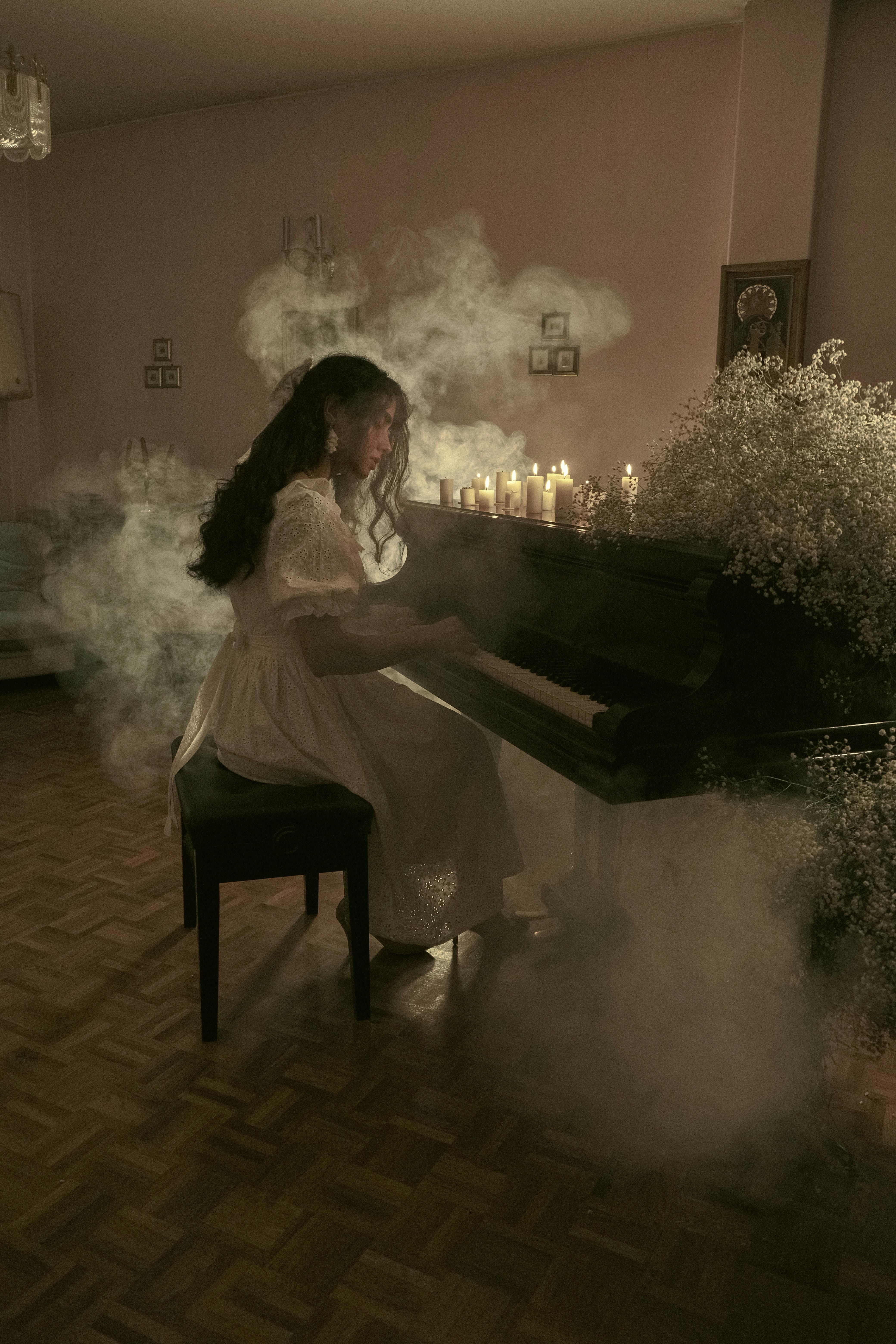 A woman playing the piano in a room with smoke · Free Stock Photo