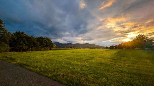 Free Capture of a vibrant sunset over a lush green field in Ainring, Germany, showcasing rural tranquility. Stock Photo