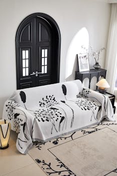 Elegant living room featuring a contemporary sofa with artistic throw and stylish decor.