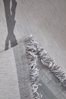 Detailed close-up of a modern textile featuring woven patterns and fringe edges.