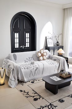 Stylish living room with a floral-patterned sofa cover, black door, and contemporary decor.