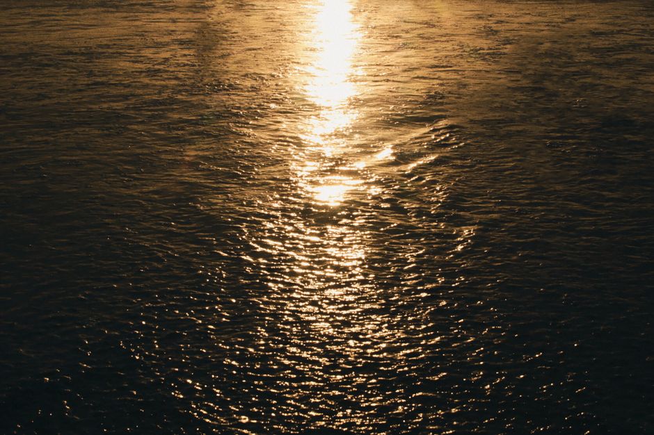Serene image of a golden sunset reflecting on a calm sea, capturing peacefulness and natural beauty.