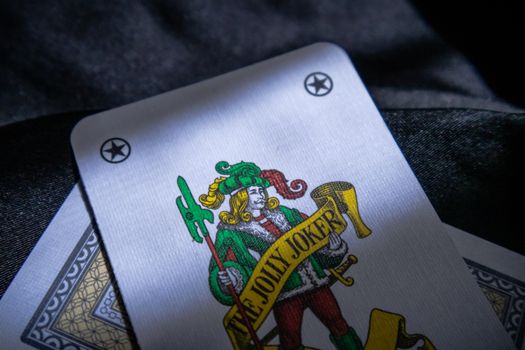 Detailed shot of a Jolly Joker playing card with intricate design in a low light setting.