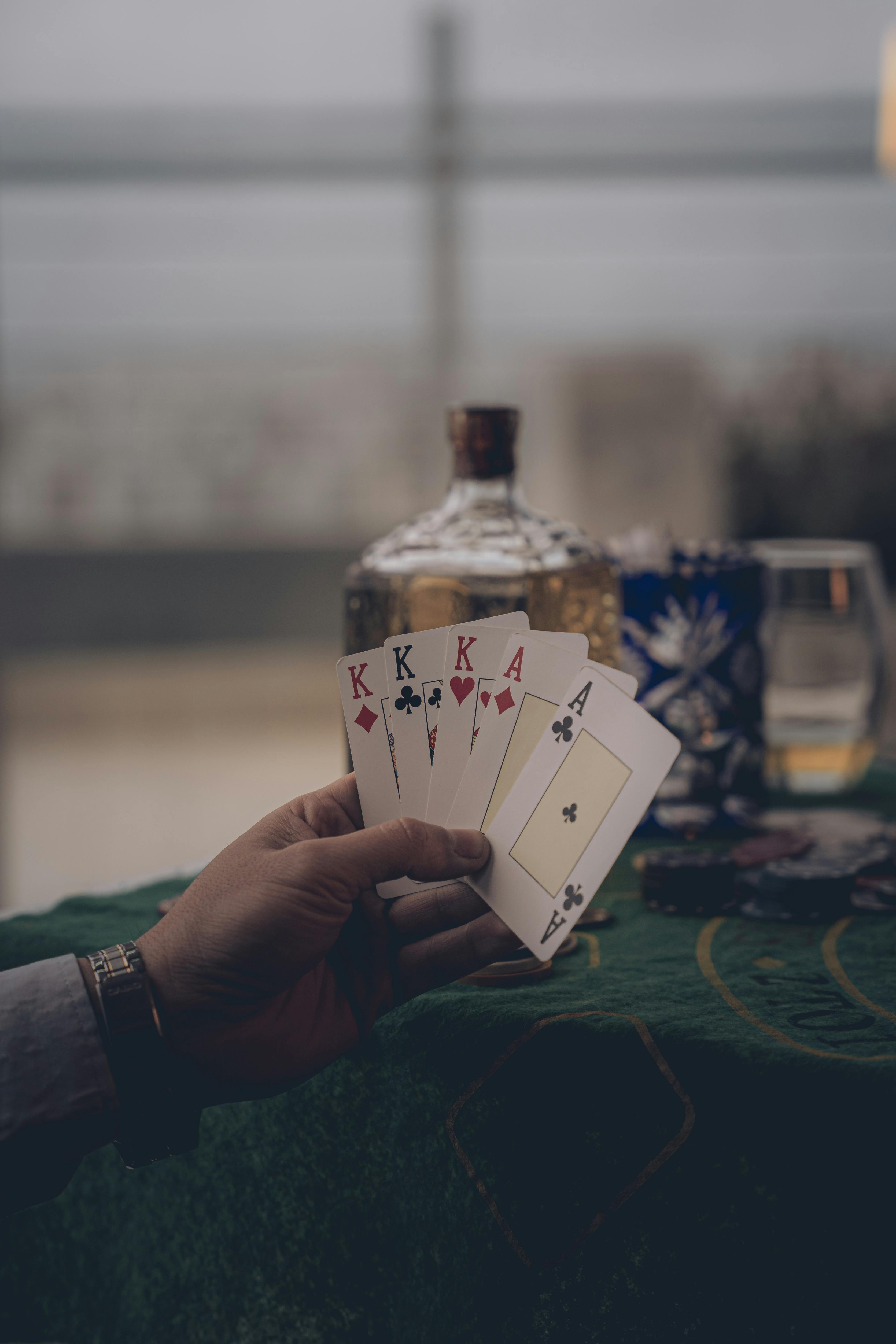 a person holding four cards on a table