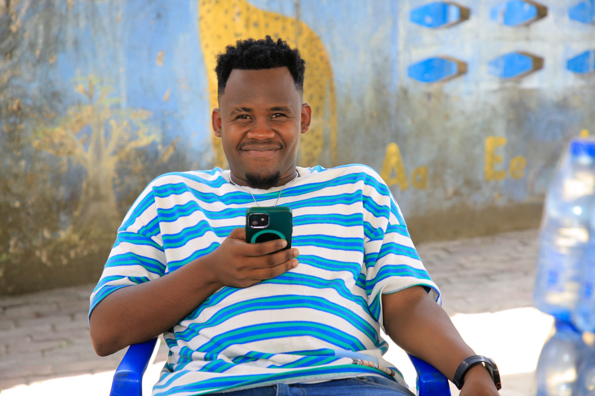 A man sitting in a chair with a cell phone