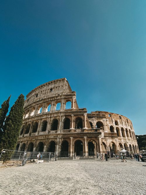 Free A breathtaking capture of the ancient Roman Colosseum under a clear blue sky. Stock Photo