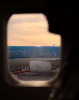 View of an airplane from the cabin window during sunset, capturing travel essence.