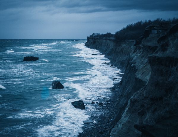 Coastal cliffs above dark ocean water — photo by Phil S on Pexels