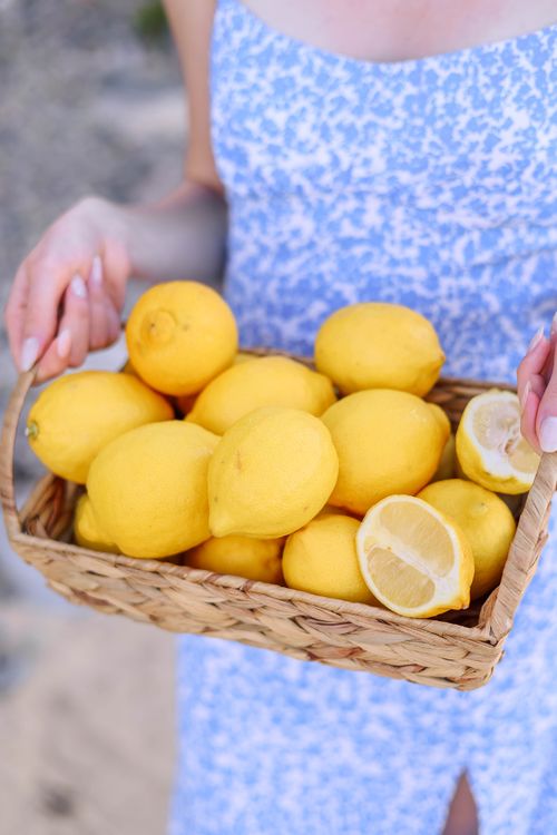Free A person holding a basket full of fresh lemons, depicting vibrant summer vibes. Stock Photo