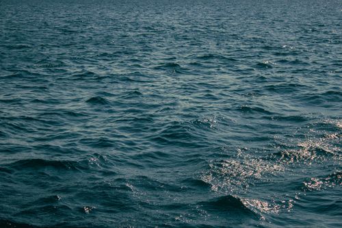 Free Captivating view of ocean waves with shimmering ripples under the sunlight. Stock Photo