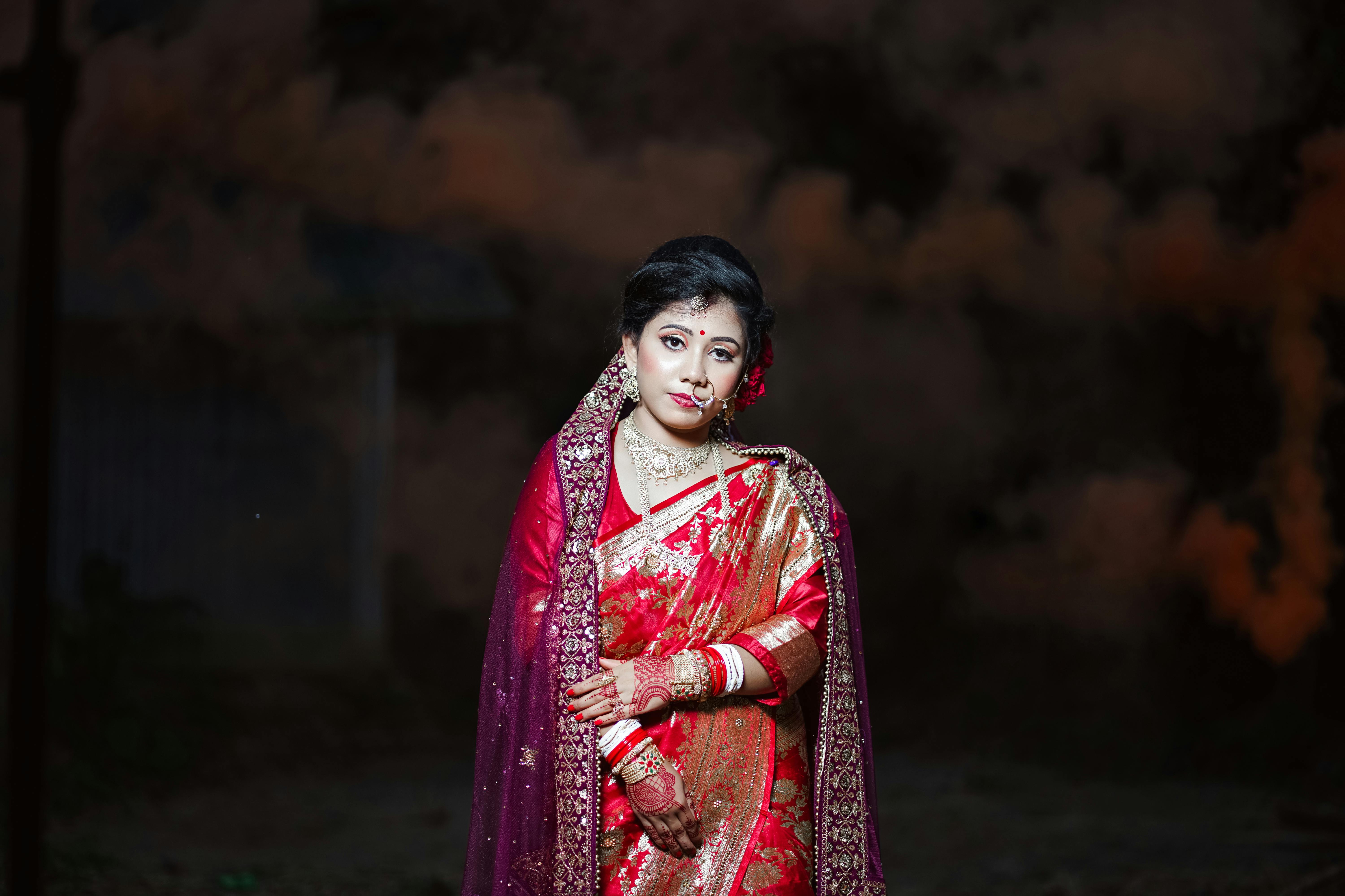 Portrait of a woman in traditional Indian bridal attire with intricate jewelry and sari.