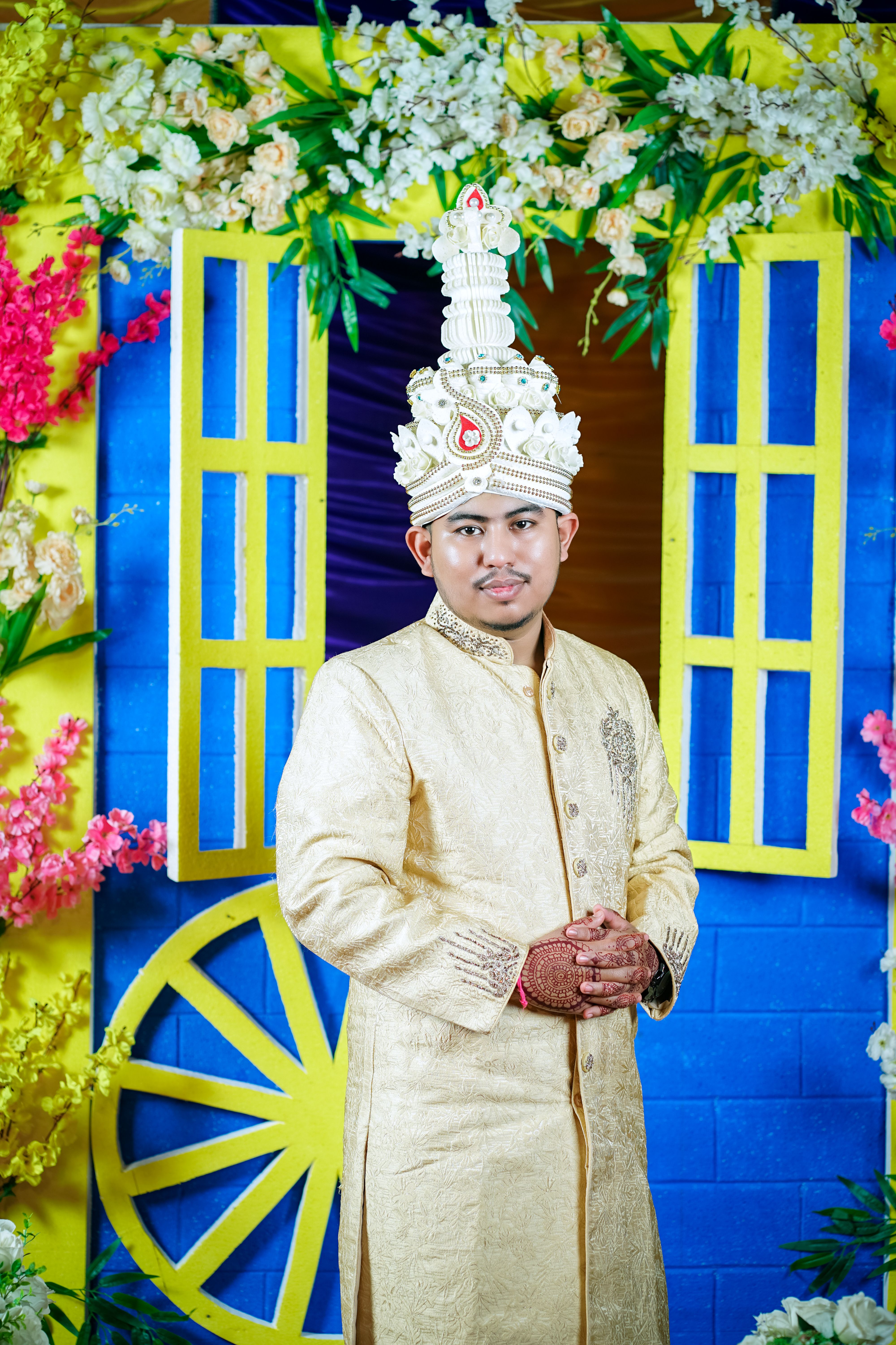 A man in a gold and white outfit standing in front of a colorful ...