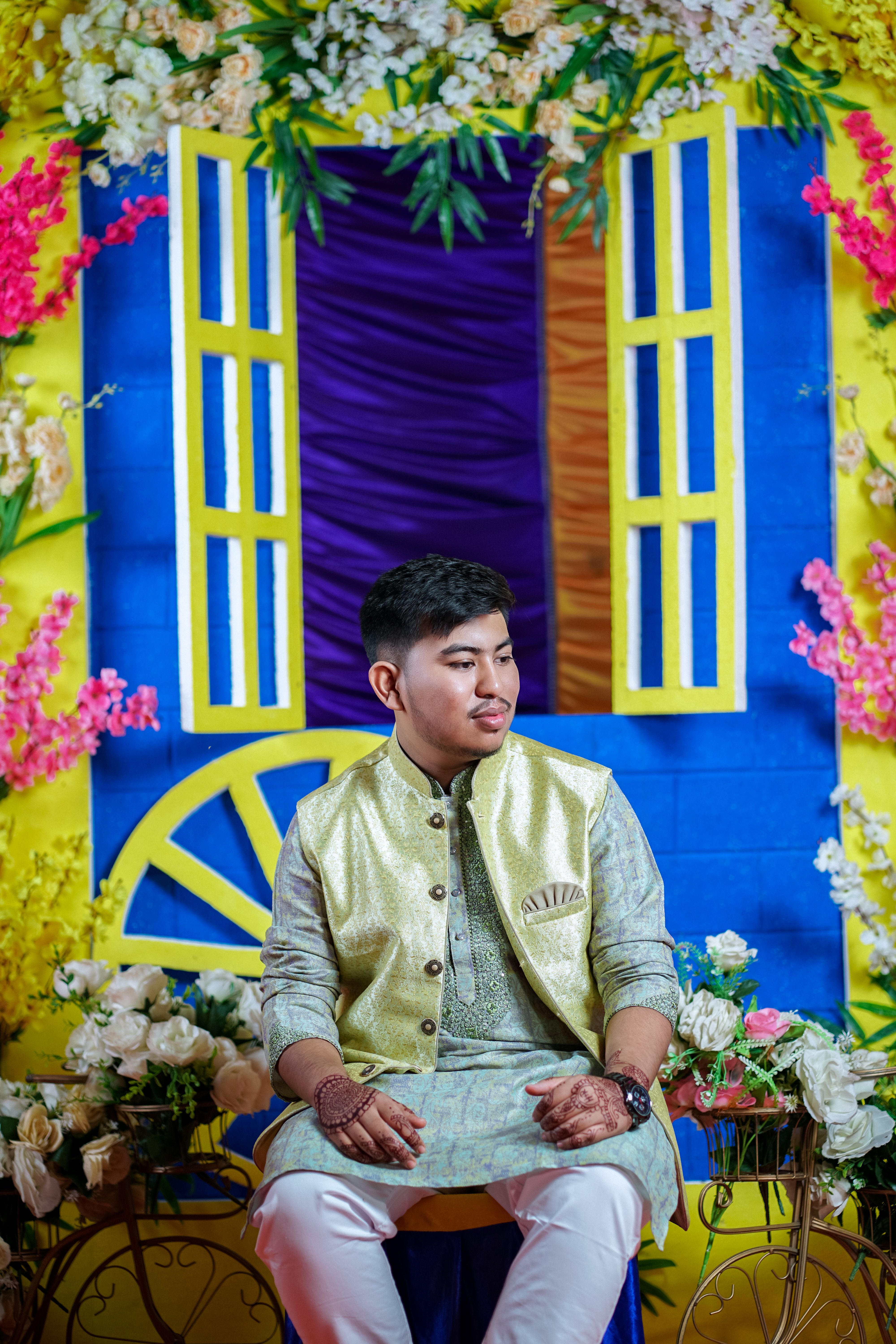 A man in a yellow and gold outfit sitting on a chair · Free Stock Photo