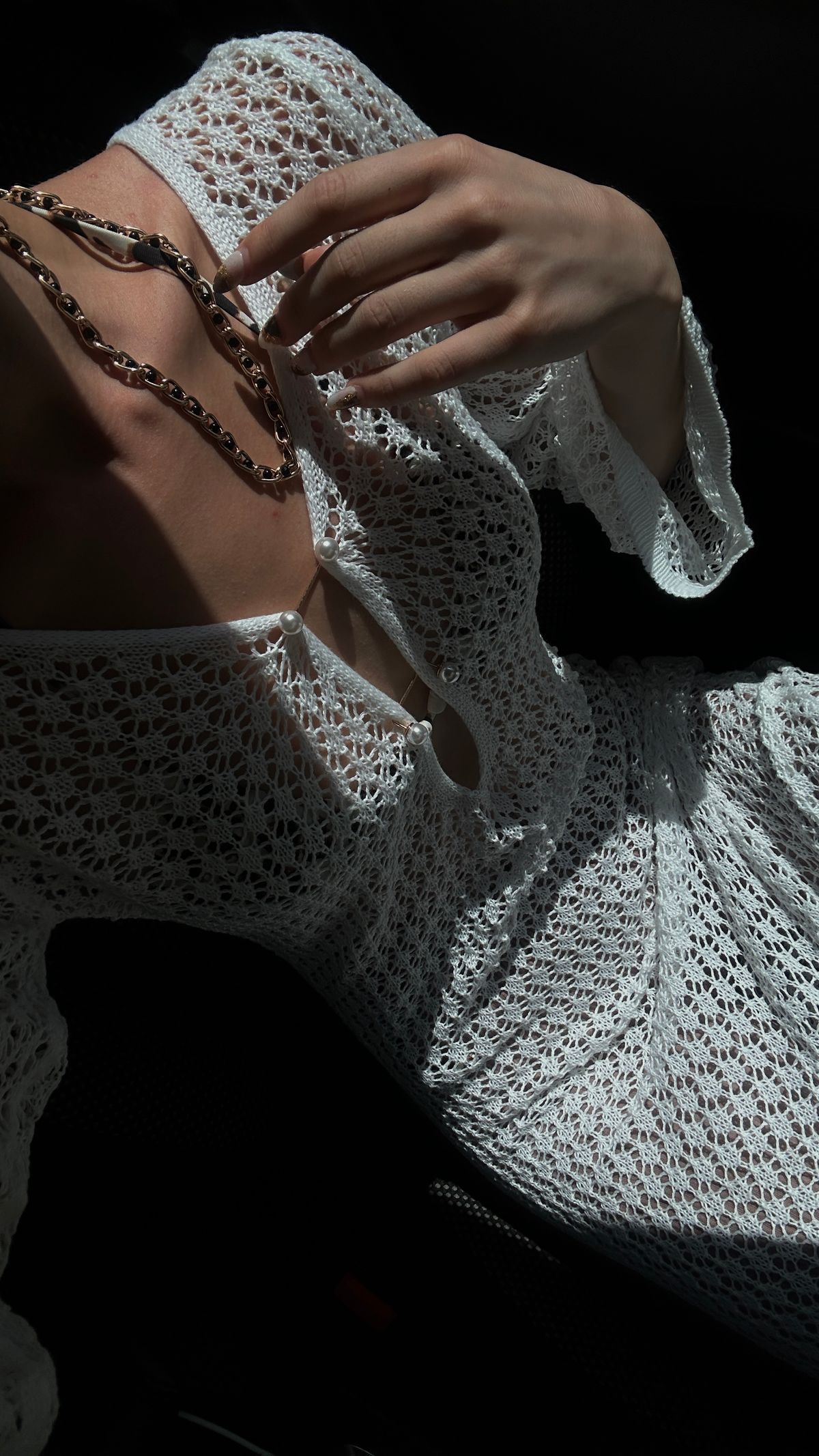A woman in a white dress with a necklace — crochet at its most elemental