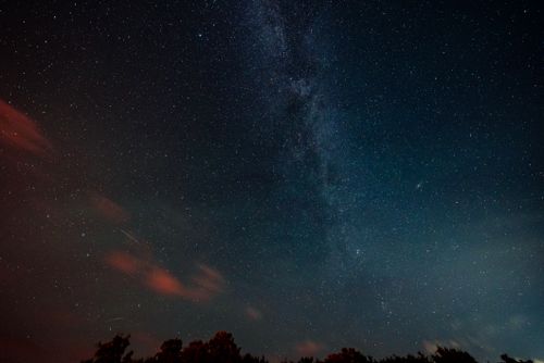 Free Vibrant night sky featuring the Milky Way and countless stars above the horizon. Stock Photo