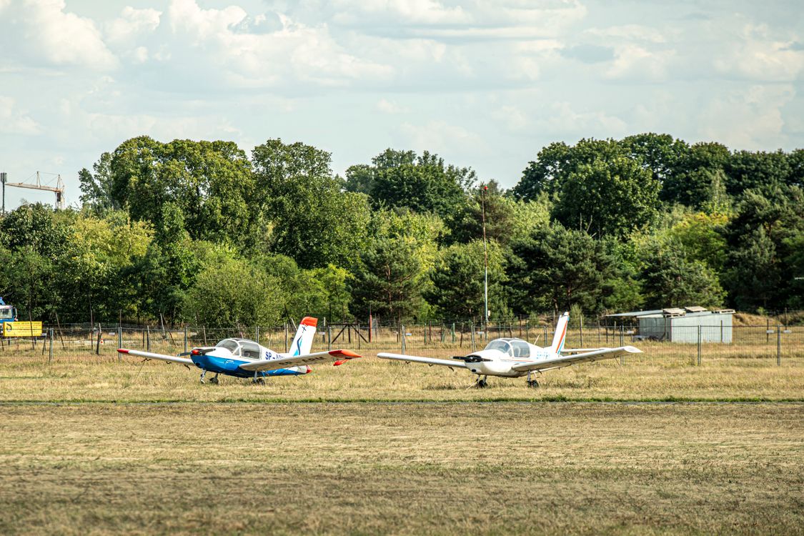 Two small airplanes are parked on a grassy field · Free Stock Photo