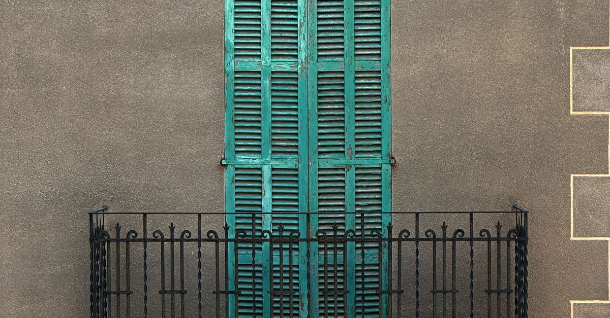 A balcony with green shutters and a balcony railing · Free Stock Photo