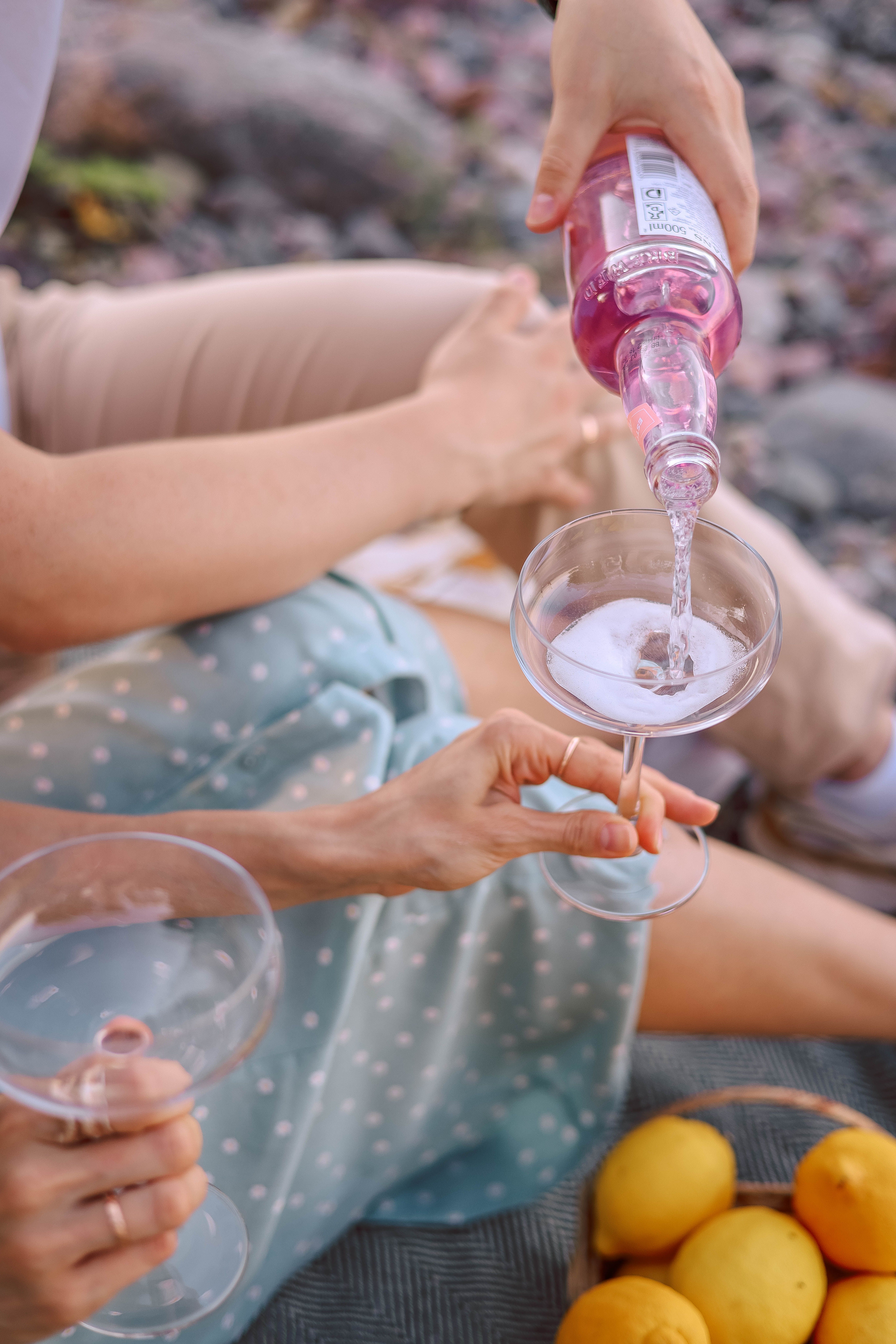 Capture the essence of summer relaxation with a picnic scene featuring refreshing pink wine and lemons.