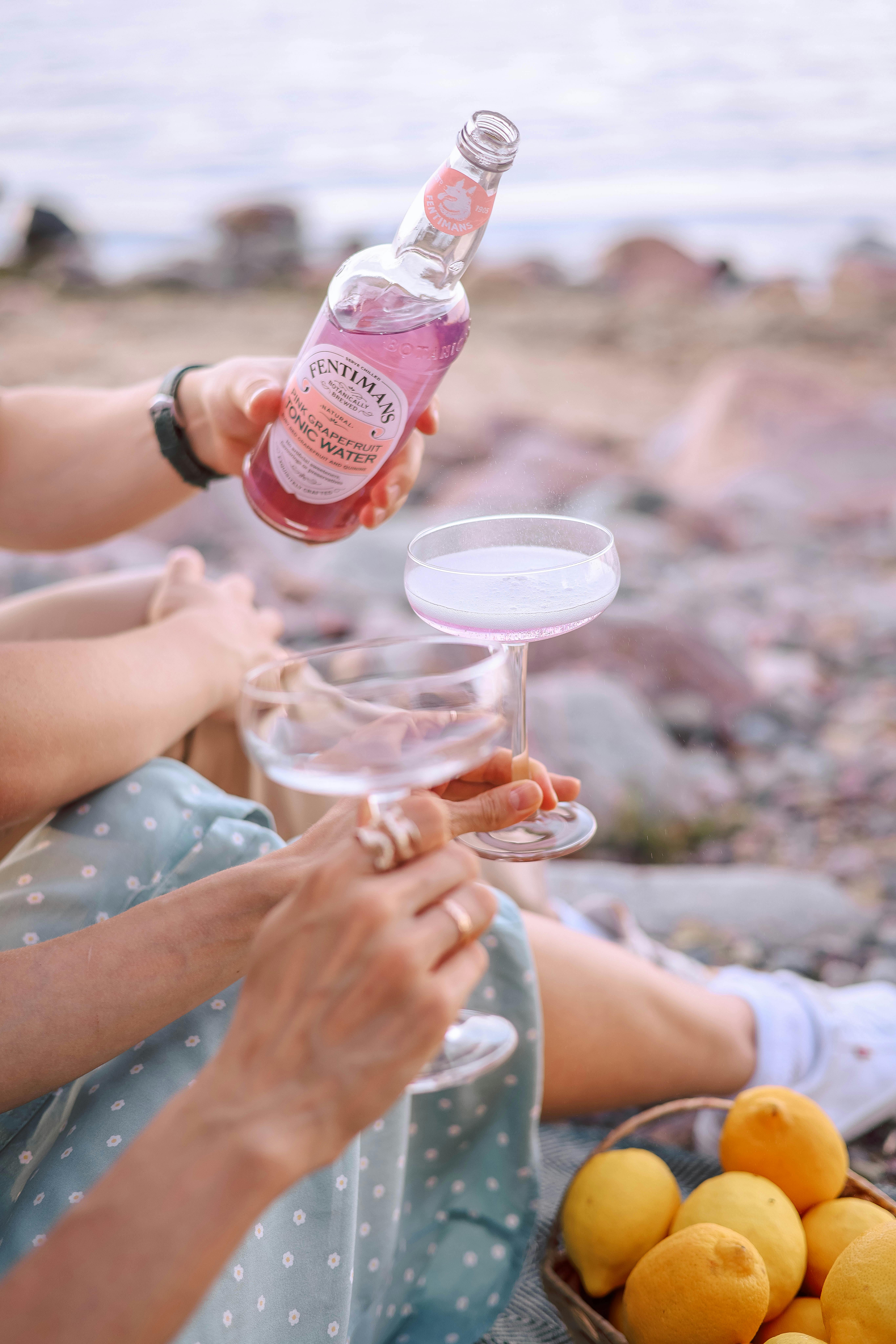 Charming summer picnic by the beach with refreshing drinks and fresh lemons, perfect for leisure and relaxation.