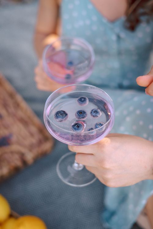 Free A close-up of a refreshing blueberry-infused drink held by a woman, perfect for summer. Stock Photo