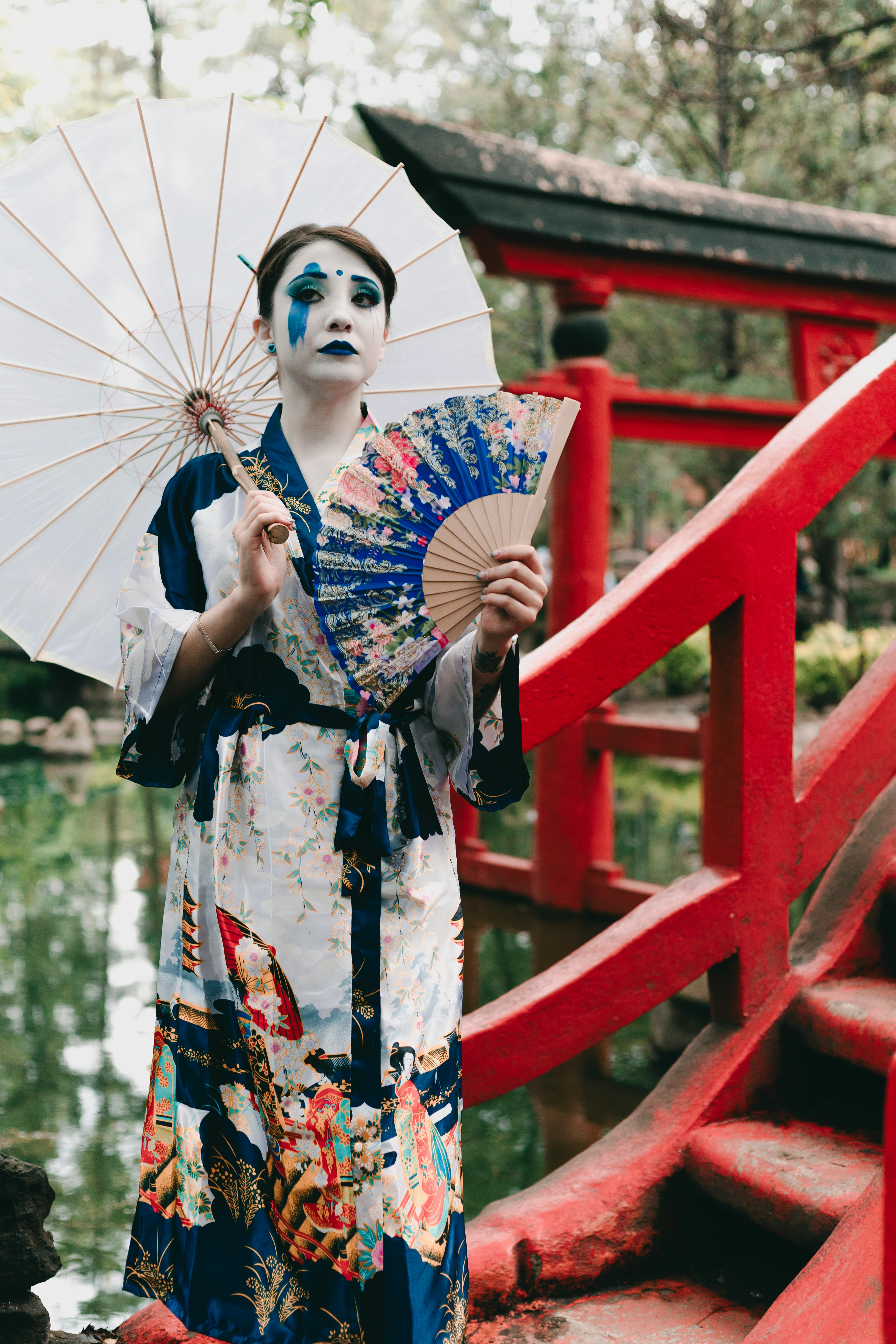 geisha in traditional clothing and with fan and umbrella