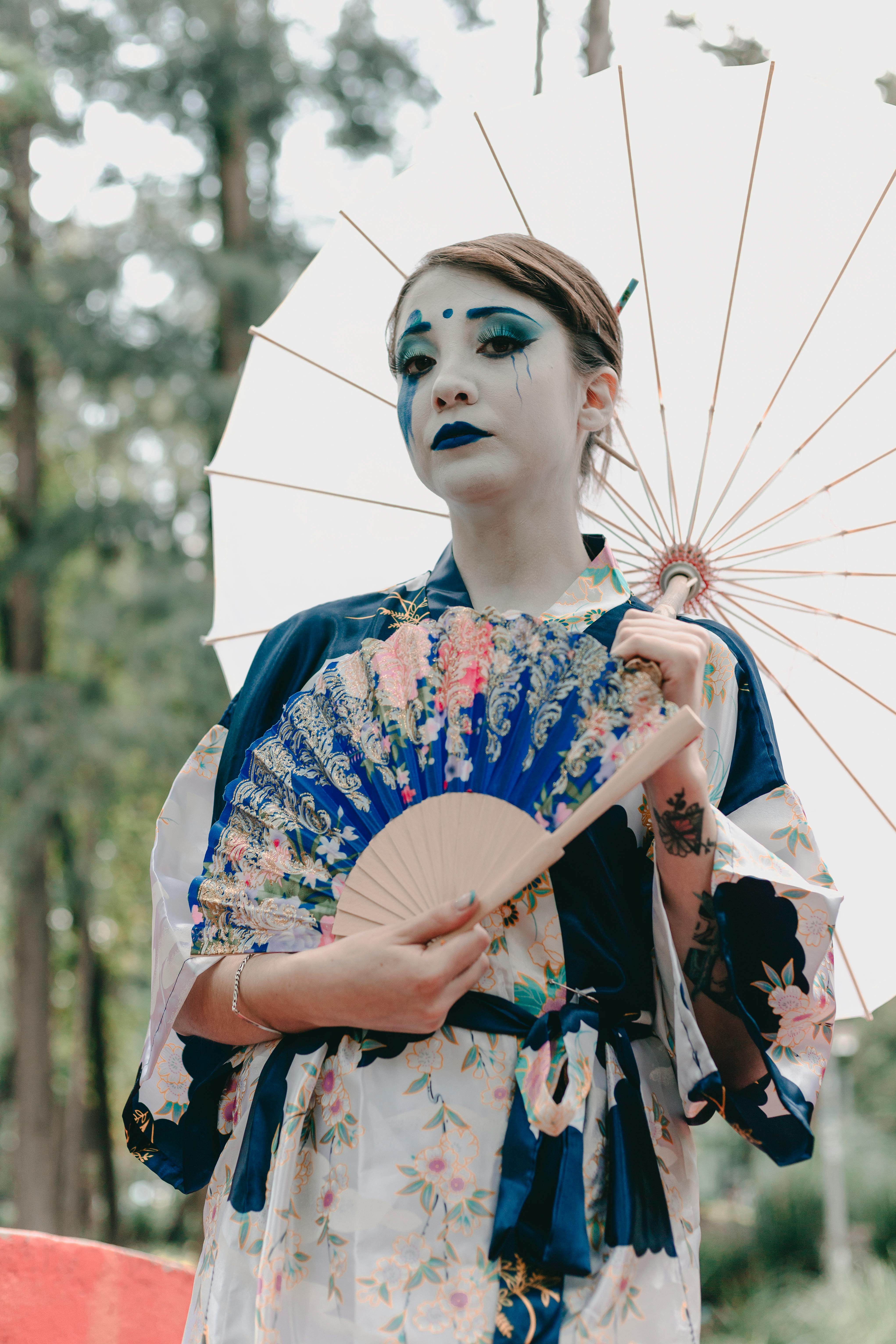 a woman in a geisha costume holding a fan