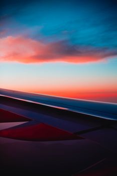 A stunning view of an airplane wing against a beautiful sunset sky, captured mid-flight.